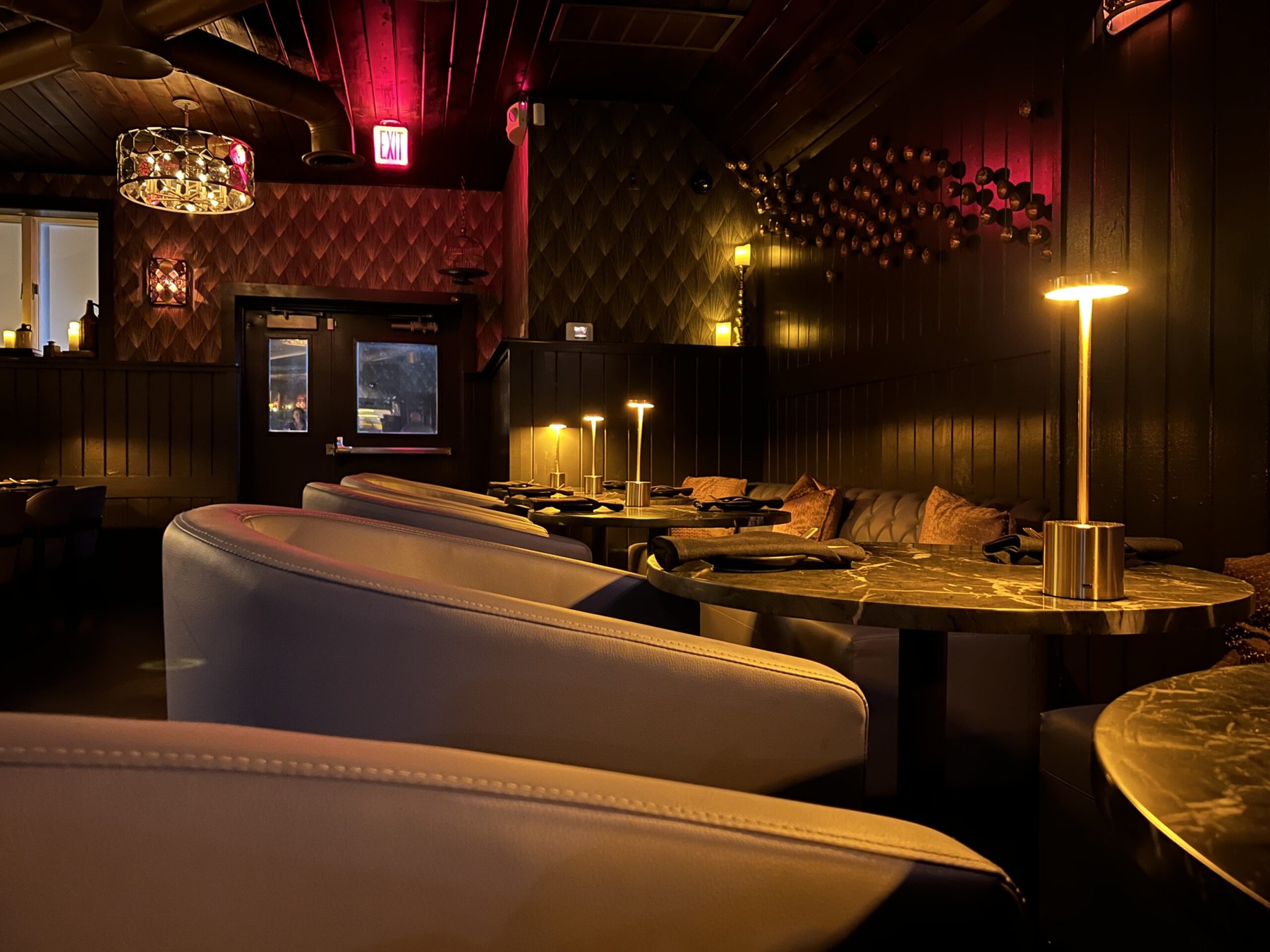 Dark wood and softly lit seating inside The Libation Room